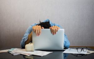 Tired man hanging over his computer